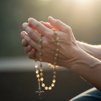 Person praying with rosary beads, serene atmosphere